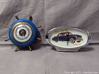 Photo showing the German barometer with blue ship wheel frame and Old Navy clock with vintage car design side by side