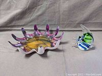 Two glass figurines displayed: a starfish-shaped bowl and a small fish figurine.