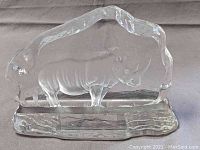 Clear glass rhino sculpture viewed from front angle showing detailed rhino inside glass slab and visible textured edges