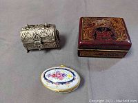 Three closed trinket boxes seen from above showing exterior designs and sizes.