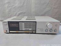 Front view of silver Sony STR-VX22 stereo receiver showing digital tuner display, buttons, and control knobs.