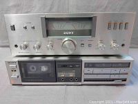 Front view of Sony TA-313 integrated amplifier stacked on top of Sony TC-FX33 cassette deck showing control knobs, buttons, and cassette compartment
