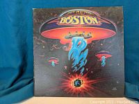 Front album cover showing Boston spaceship artwork with Earth below and glowing flames.