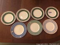 Seven Wedgwood Queen's Ware 6 inch salad plates laid out on table, showcasing green and blue floral borders.