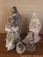 Main group of five figurines on shelf including NAO nativity figurine and others