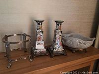 Overview of candlesticks, brass stand and decorative bowl on wooden surface
