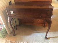 Front view of closed desk showing frieze drawer and cabriole legs