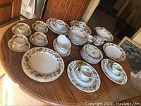 Overall view of all dinnerware pieces laid out on oak table