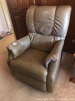 Full view of the La-Z-Boy recliner in brown leather upholstery showing padded armrests and high back.