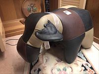 Three-quarter view of patchwork leather moose ottoman showing shape and coloration