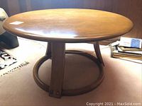 Full view of the maple coffee table, showing round top surface and circular base ring.