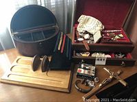 Full view of jewelry boxes and contents including watches, rings, crucifix, and display stands.