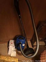 Overview of vacuum unit, wand, hose, floor nozzle, manuals and dust bag box