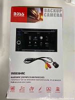 Front of box showing receiver screen and backup camera images with cables and brand information
