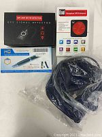 Boxed GPS Signal Anti Spy RF Detector, Dual Universal GPS Receiver box, Wiseup camcorder cap in plastic, and camcorder pen box.