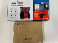 Boxes of all four devices: Oasser P7 air compressor, smart garage controller, Mpow car mount, and Gooloo jump starter.