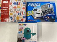 Photo showing boxed Beebeerun Happy Kitchen Playset, ShanNa Police Garage Series Plane in box, and Quincy Robot Artist box.