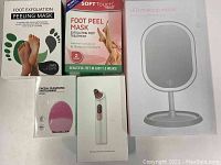 Four boxed foot peel masks, facial cleansing brush box, blackhead remover box, and LED makeup mirror box.