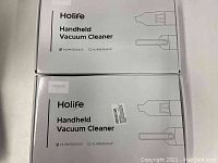 Top view of two white boxes labeled Holife Handheld Vacuum Cleaner model HLHM555ASUS.
