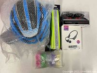 Blue and white bicycle helmet, sealed Ilumiseen LED belt, bone conduction earphones in box, five sets of small bicycle lights in colored plastic wrapping