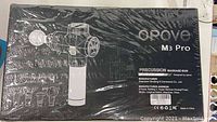 Sealed black Opove M3 Pro packaging with percussion massage gun illustration and specification label