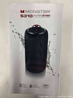Front box view of sealed Monster S310 Superstar speaker showing product image with splash water graphic and key features like 16+ hours battery life, IPX5 water resistance, Pulse Monster Sound.