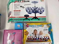 Lot items with original packaging: jazz drum set box, music mat, pink cat headphones, smart watch box visible