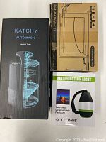 Three boxed items: Katchy Insect Trap, Portable Digital TV, Multifunction Light