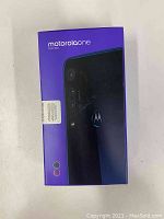 Front of sealed retail box showing Motorola One Macro branding and phone rear image