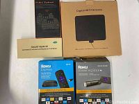 Photo of Roku Express HD and Roku Streaming Stick+ in their boxed packaging along with 2.4G air mouse smart remote and digital HDTV antenna boxes and H9 mini keyboard box