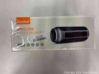 Top and front of sealed Zamkol wireless Bluetooth speaker box showing product image and brand, with IPX6 waterproof rating and wireless stereo speaker branding.