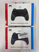 Front view of two retail boxes for wireless controllers showing black controllers with blue and red trim and wireless icon on the box