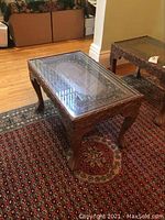 Three-quarter view of carved side table showing overall design and condition