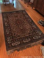 Full view of beige oriental rug laid on hardwood floor