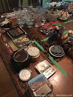 Overview of collectible spoons, glasses, coasters, and decorative items arranged on table