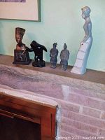 Soapstone carvings and porcelain figurine on mantle