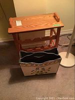 Oak and particle board bottle holder table with a top flat surface and bottle slots on bottom shelf
