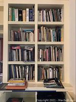 Wide view of six shelves filled with assorted books and magazines on art, languages, and history.