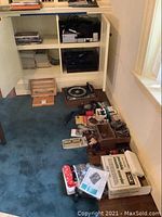 Wide view of floor showing turntable, magazines, boxes and small electronics