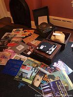 Display of multiple 33 rpm vinyl records spread out with a Dual 1009 turntable in a wooden case nearby.