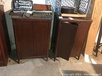 Two wooden record cabinets side by side, one with doors closed and the other with one door open.