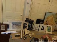 Group of matted prints and original oil painting leaning against wall