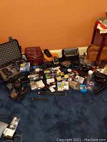 Multiple cameras, lenses, tripods, cases and accessories arranged on floor