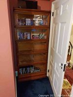 Full frontal view of five-section oak barrister bookcase against wall