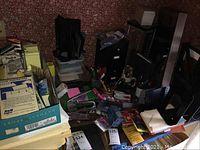 Overhead view of various office supplies including file folders, staplers, planning materials, and small storage containers.