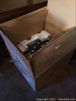 Photo of a large cardboard box containing the TEAC reel to reel player partially wrapped and protected by styrofoam inserts.