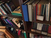 Bookshelves with various science, art, and microscopy books along with binders and magazines