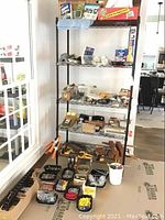 Photo of shelves and containers filled with assorted clamps, washers, trailer hitch and cord grip.