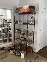 Full view of the black metal metro shelf holding various items, showing its overall structure, size, and design.