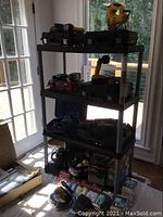 Full view of one shelving unit with various tools stored on it, near glass doors and windows showing sunlight.